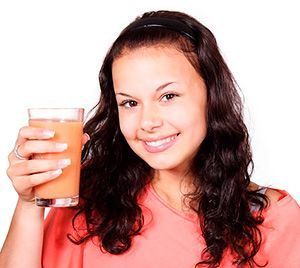 El Jugo de Fruta puede no ser tan Saludable como Crees 1 jugo de fruta mujer joven tomando el jugo de fruta
